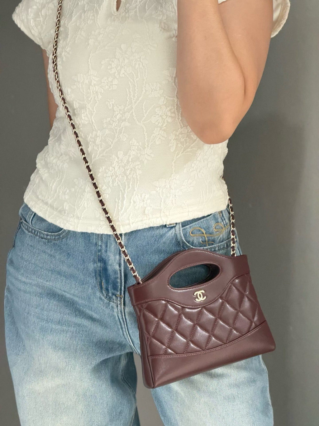 Burgundy quilted mini handbag worn crossbody