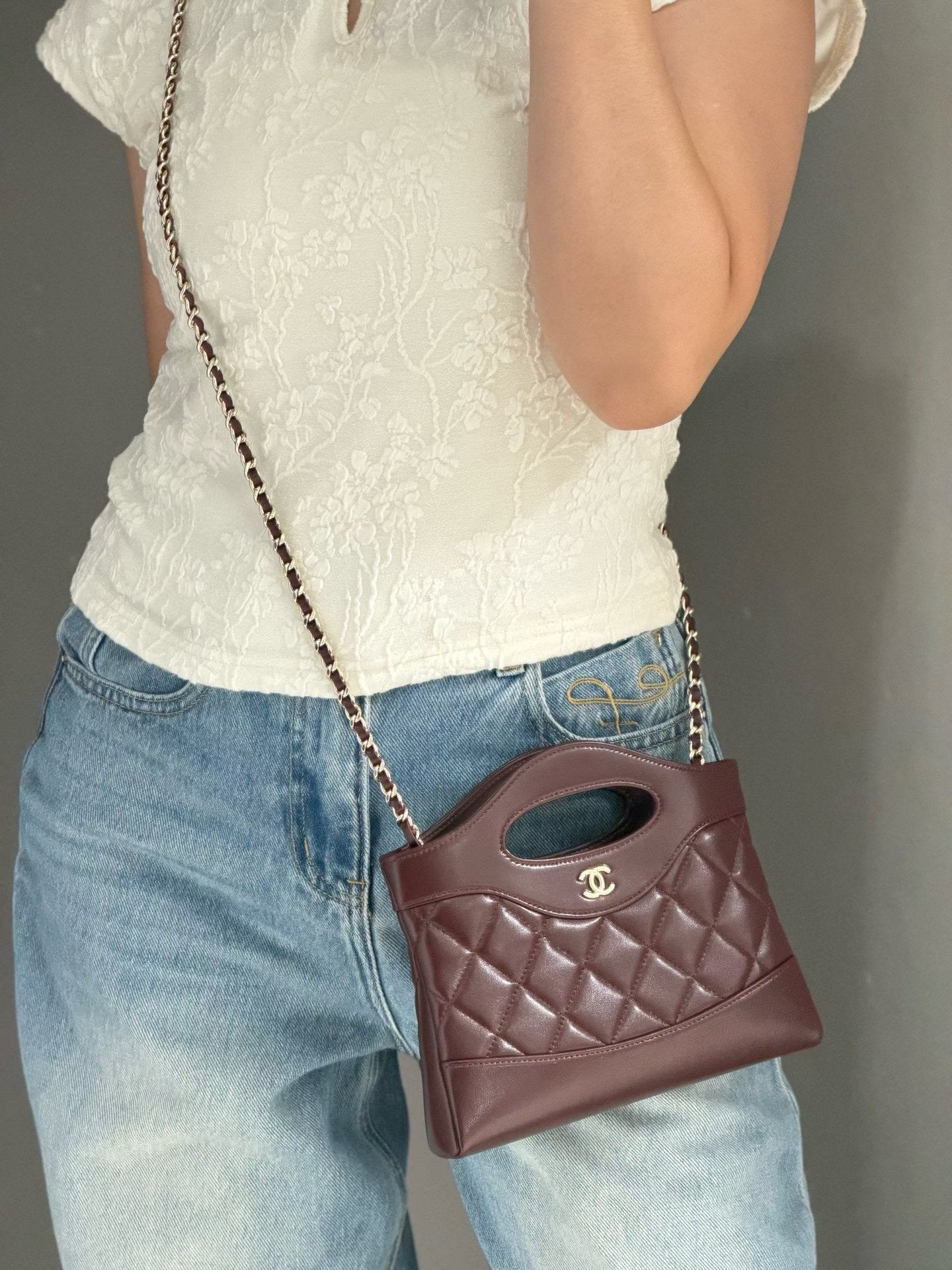 Burgundy quilted mini handbag worn crossbody