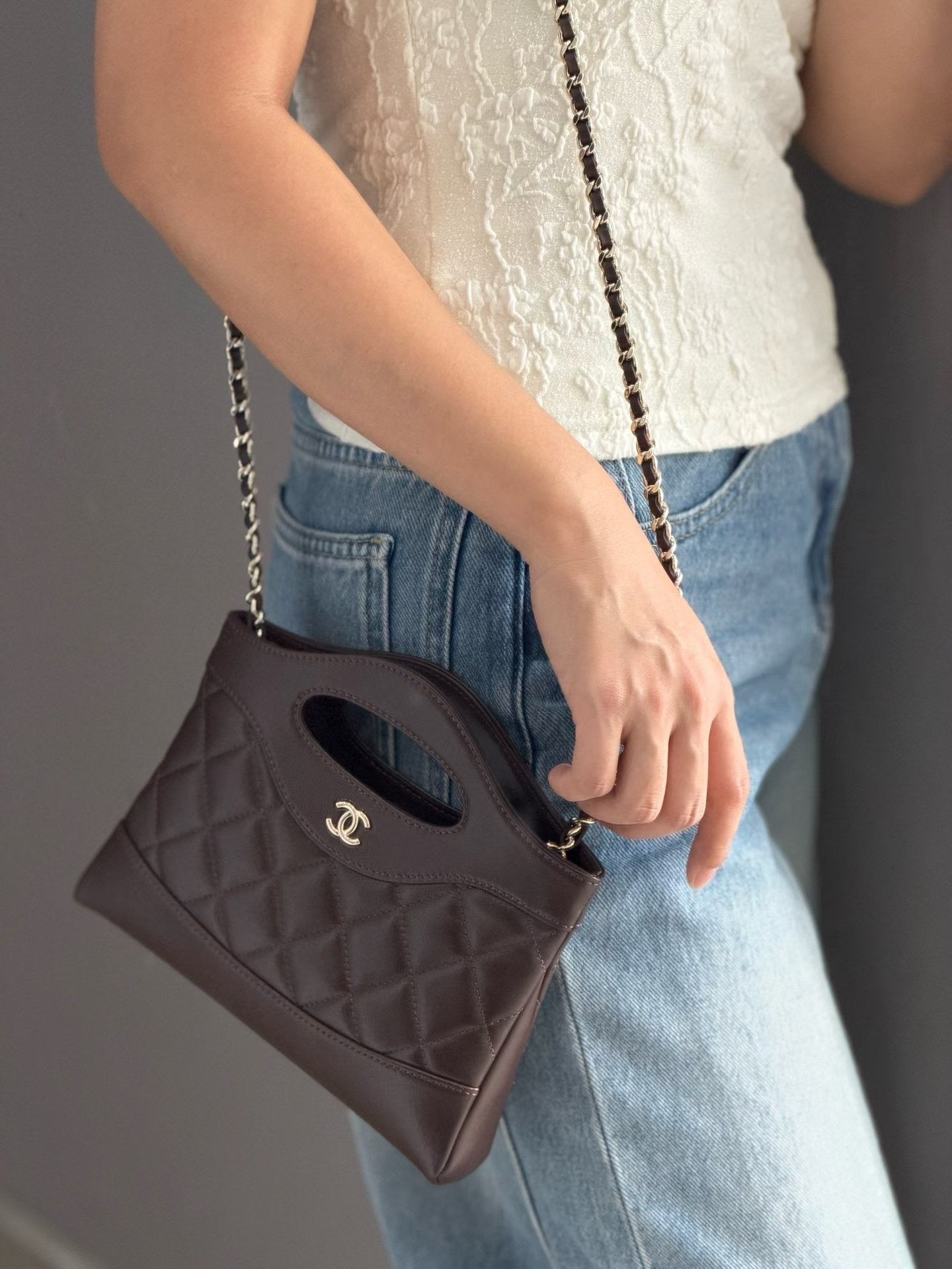 Dark brown quilted mini handbag shoulder view